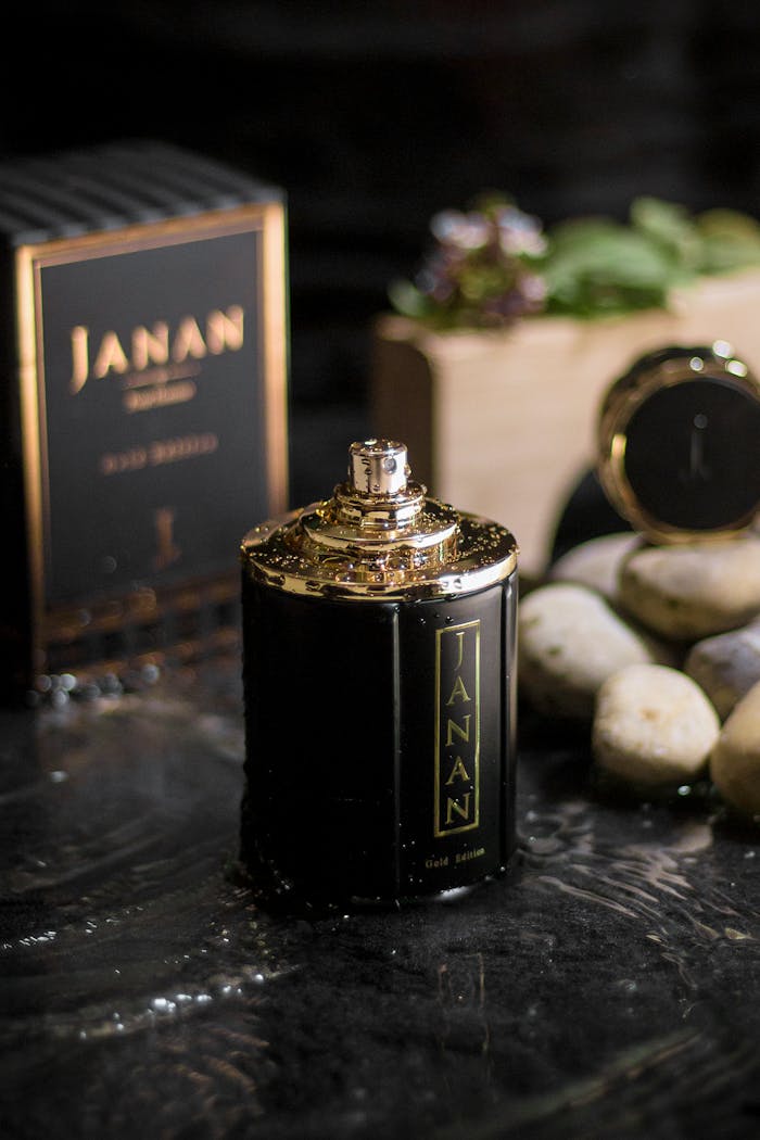 Close-up of a luxurious perfume bottle with natural stones and box, showcasing elegance and fragrance.
